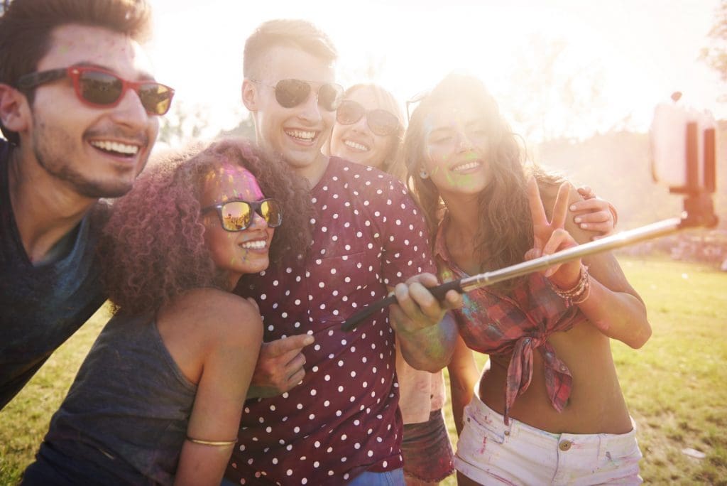millennials taking selfie with selfie stick