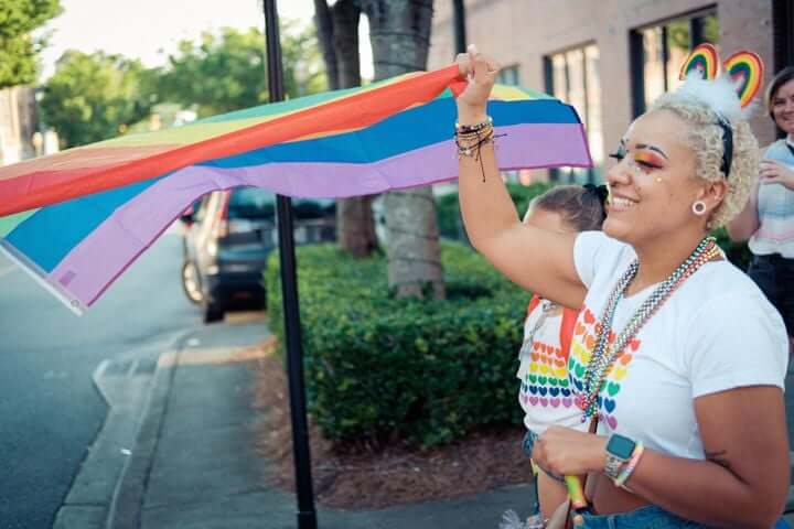 event-goer waving pride flag at rock hill pride festival
