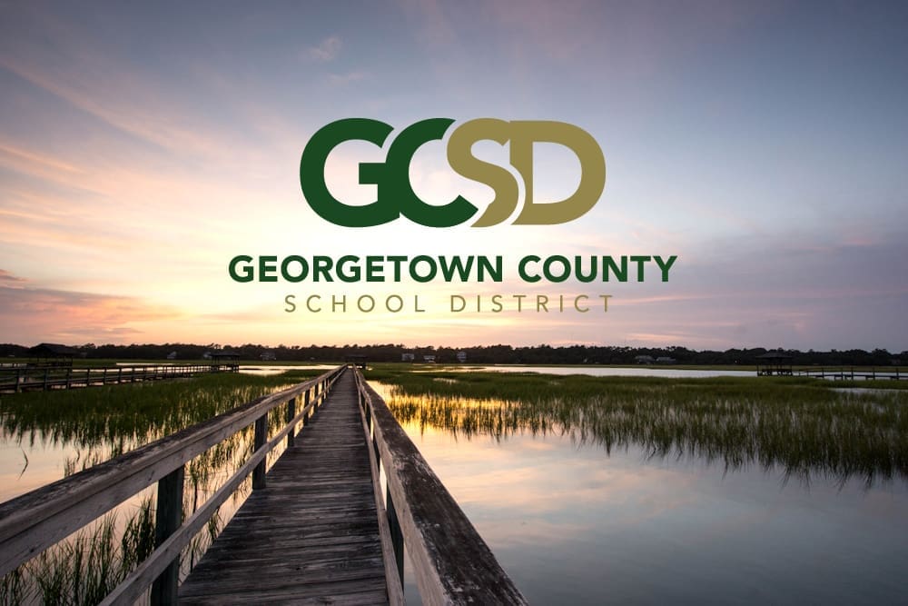 boardwalk on the marsh in Pawleys Island, South Carolina at sunset with Georgetown County School District logo