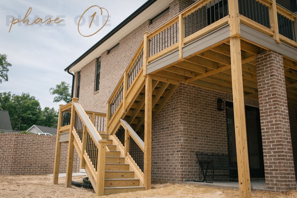 deck and stairs being built onto house. "Phase One" logo is in the top left